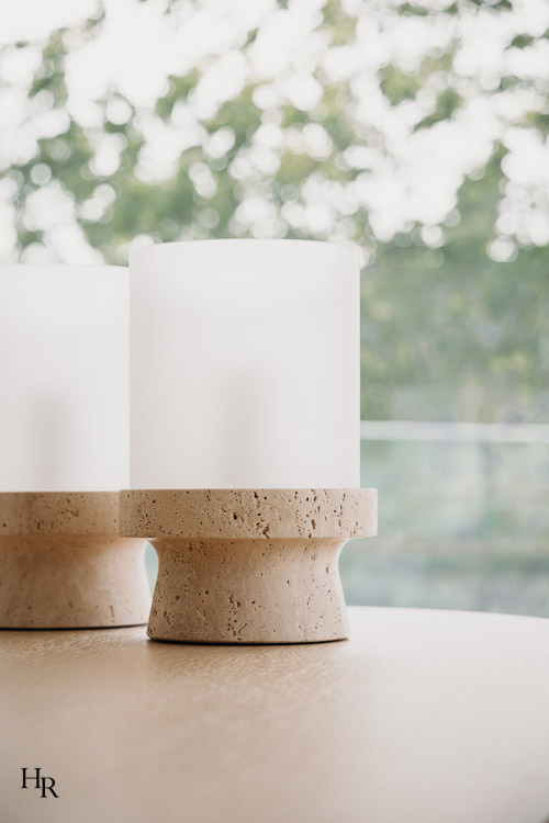 Detailaufnahme dekorativer Tischleuchten mit Travertinfuß auf einem Holztisch – Interior Design von Hendrik Ritschel