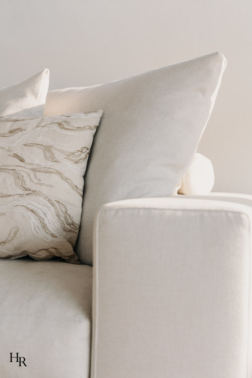 Detailaufnahme eines hellen Sofas mit strukturierten Kissen und fein abgestimmten Stoffen – Interior Design von Hendrik Ritschel