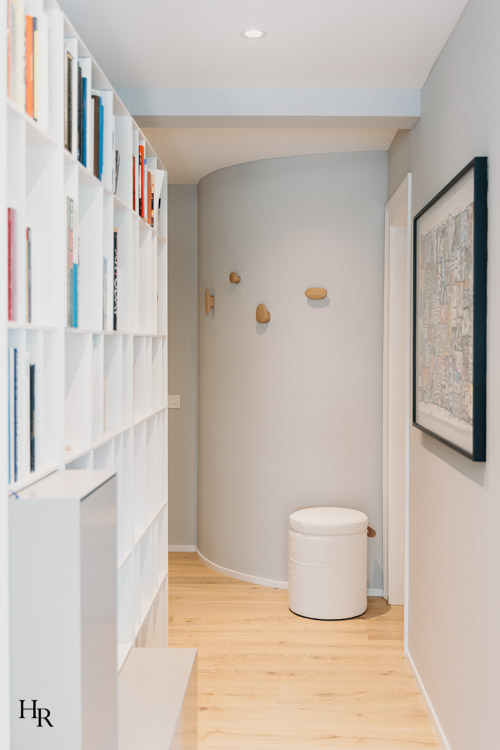 Flur mit Bücherregal, geschwungener Wand und hellen Holzakzenten – Interior Design von Hendrik Ritschel